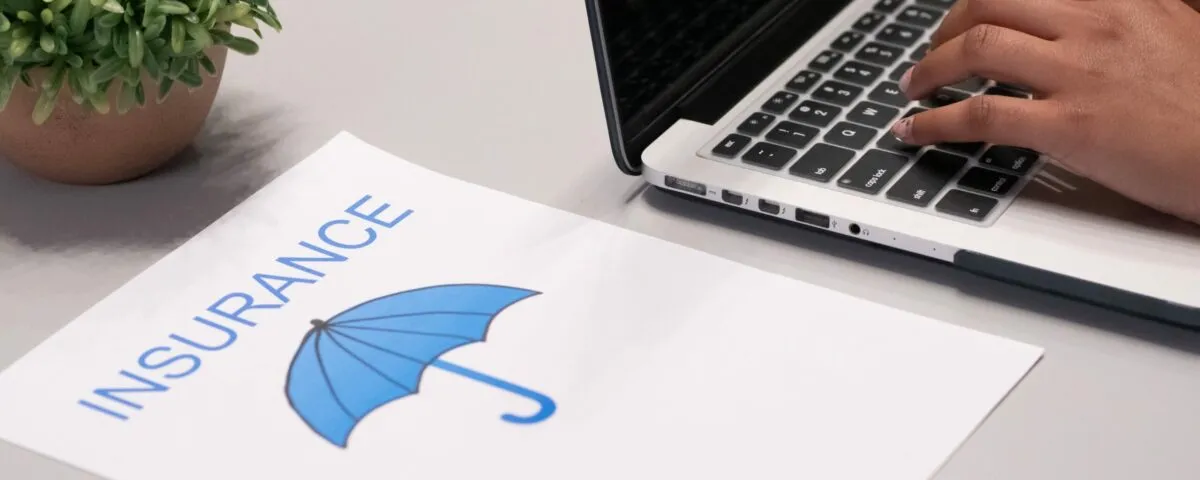 Free A Paper beside a Person Typing on a Laptop Stock Photo