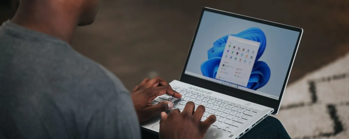 man in gray long sleeve shirt using Windows 11 computer