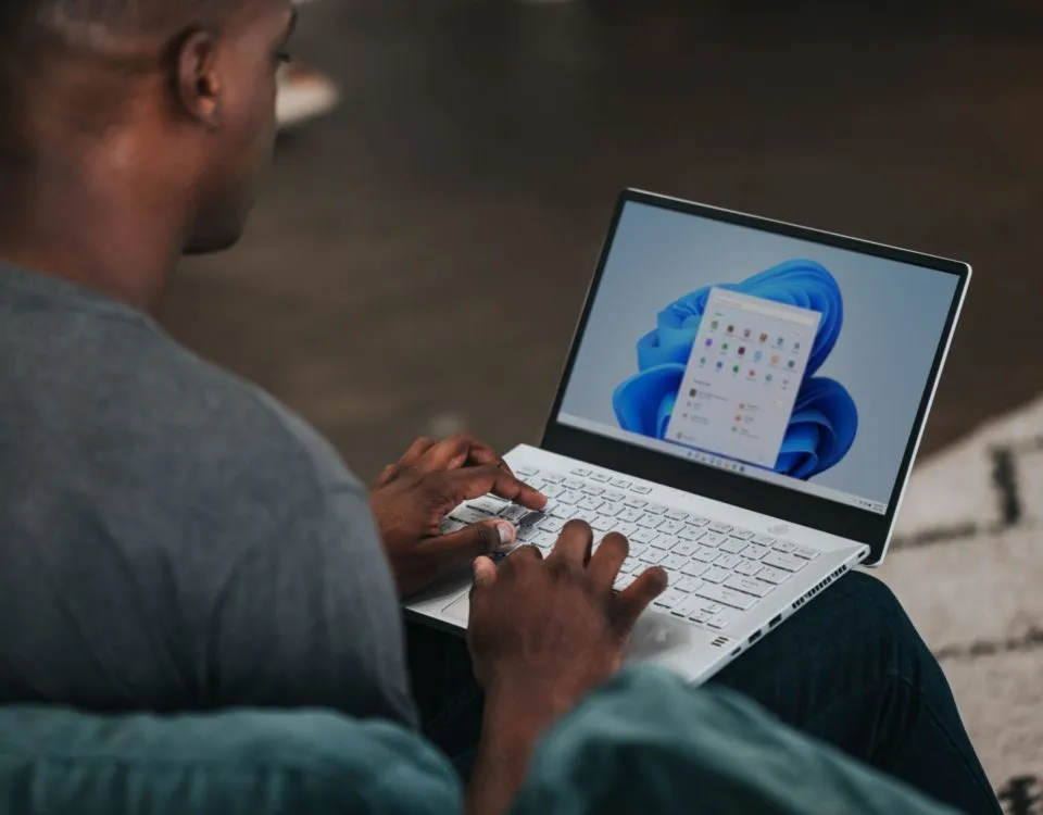 man in gray long sleeve shirt using Windows 11 computer